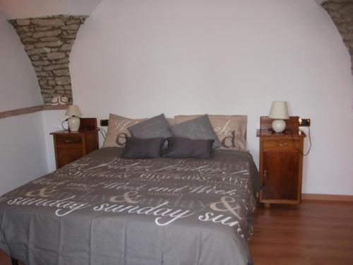 a bedroom with a bed and two night stands at APPARTAMENTO AURORA Val di Sogno in Malcesine