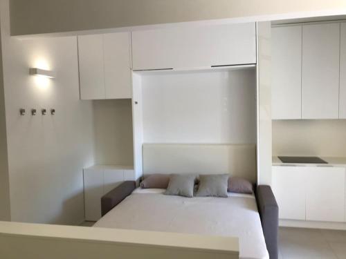 a bedroom with a white bed and white cabinets at Olivo House 1 in Portovenere