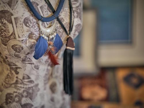 a necklace with blue feathers on a curtain at Nobelos Seaside Lodge in Agios Nikolaos