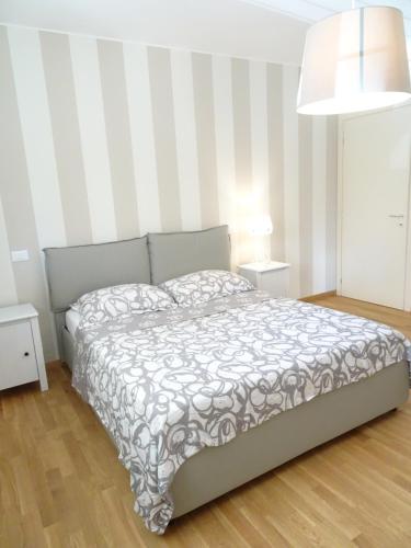 sypialnia z łóżkiem i ścianą w paski w obiekcie Italy Home w mieście San Costanzo