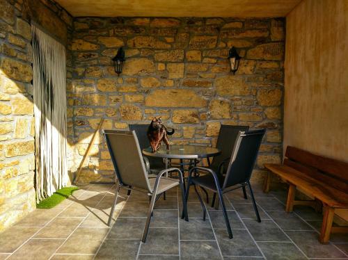 uma mesa e cadeiras num quarto com uma parede de pedra em Casa rural El Gato Negro em Trefacio