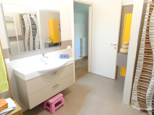 łazienka z białą umywalką i lustrem w obiekcie Italy Home w mieście San Costanzo