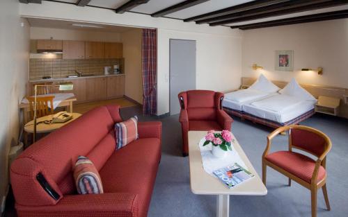 um quarto de hotel com um sofá e cadeiras e uma cama em Hotel Zur Mühle em Buxtehude