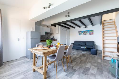 une cuisine et une salle à manger avec une table et des chaises en bois dans l'établissement Le Grand Bleu- Superbe Maison avec Terrasse vue sur Mer, à Marseille