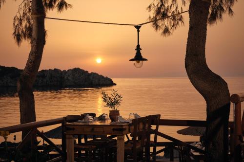 a table with a sunset over the water at Nobelos Seaside Lodge in Agios Nikolaos