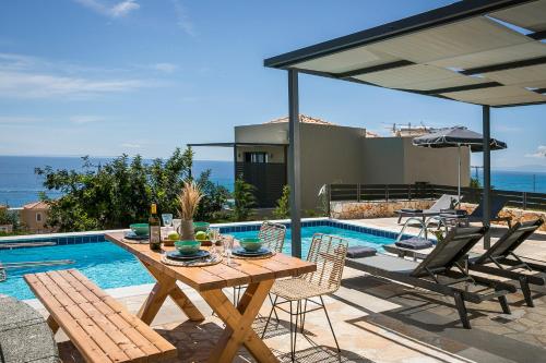 a patio with a table and chairs next to a pool at Villa Blue Sea in Skala