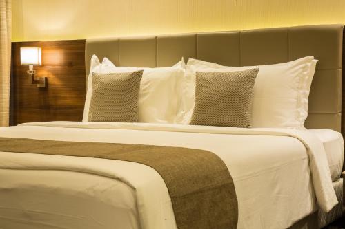 a large bed with white pillows in a hotel room at Iscon The Fern Resort & Spa, Bhavnagar in Bhavnagar