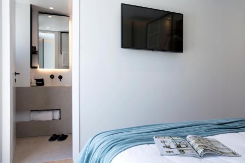 ピレウスにあるThe Alex Monte Kastellaのベッドルーム1室(ベッド1台、壁掛けテレビ付)
