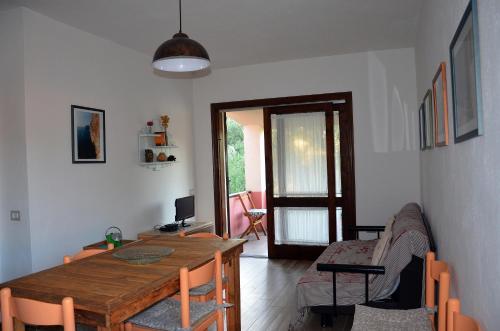 un soggiorno con un tavolo di legno e un divano di Casa Smeralda a Cannigione