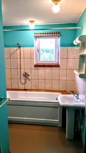 a bathroom with a tub and a sink and a window at Гостевой таунхаус in Demidov