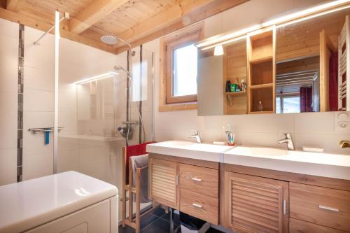 Un baño con dos lavabos y una ducha. en La Griotte, en Morzine