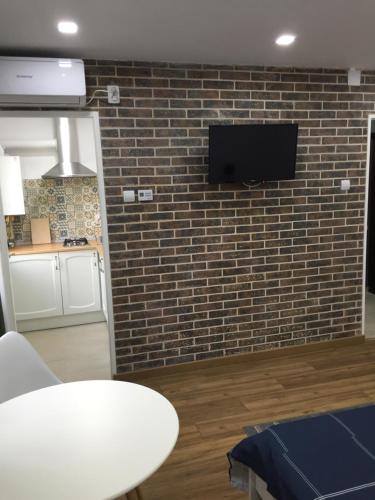 a room with a brick wall with a tv on a wall at Studio Claudia-self Check-in in Brăila
