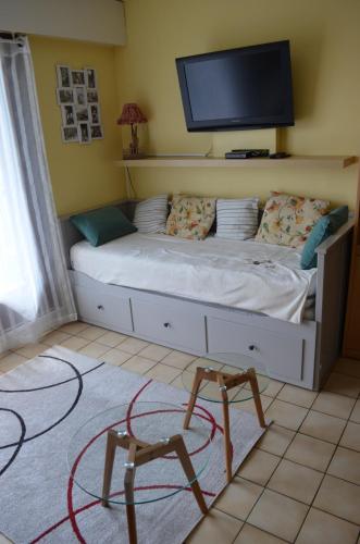 - une chambre avec un lit et une télévision murale dans l'établissement Les Dryades L'Epicéa, à Gérardmer