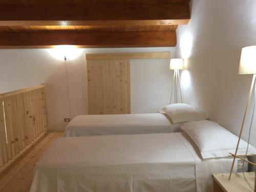 Un dormitorio con dos camas y un techo. en BORGO PETELIA, "Casa Perri", antica casa ristrutturata con terrazzo, en Strongoli