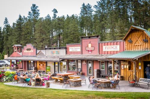 a group of people sitting at tables outside of a lodge at Lodge at Palmer Gulch in Hill City