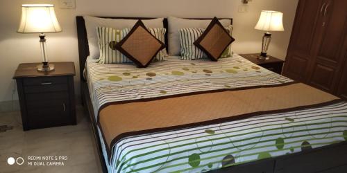 een slaapkamer met een bed met 2 nachtkastjes en 2 lampen bij Short Stay Luxury separate 3BHK in green park near metro with lift MINIMUM 3 NIGHTS in New Delhi
