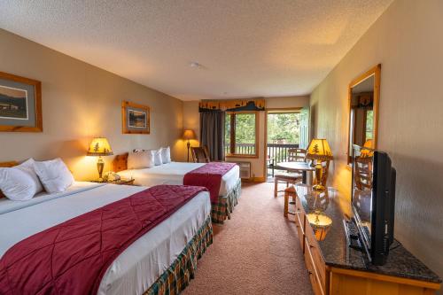 ein Hotelzimmer mit 2 Betten und einem TV in der Unterkunft Lodge at Palmer Gulch in Hill City
