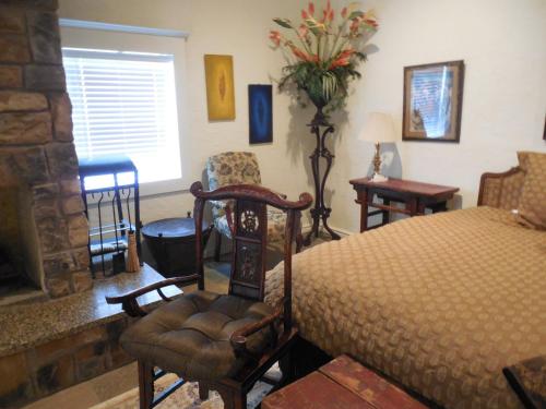 een slaapkamer met een bed en een stoel en een open haard bij Dogwood Springs Lodgings in Mineola