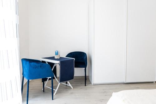 a table and two blue chairs in a room at Casa Vacanze Io Farò in Taranto
