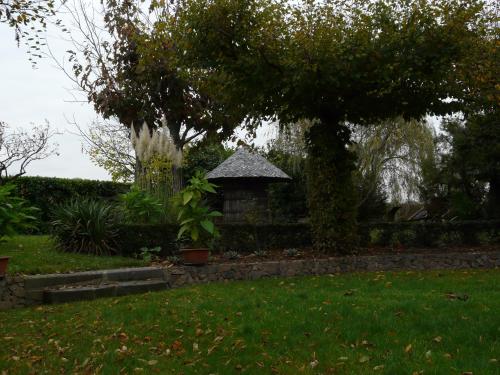 a small house in a yard with a tree at Logis Hôtel LE DAHU in Parigny