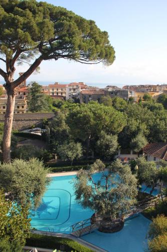 an overhead view of a swimming pool with trees and buildings at BLU SEA SORRENTO in Sorrento