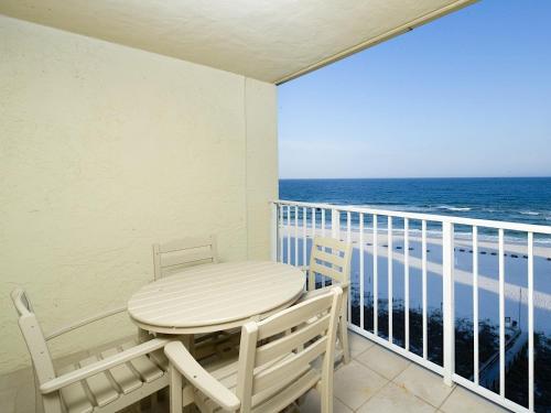 Sunswept 807 Condo في شاطئ أورانج: طاولة وكراسي على شرفة مع المحيط