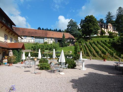 a courtyard with tables and chairs and umbrellas at Wein Lodge Durbach - Josephsberg 2 in Durbach