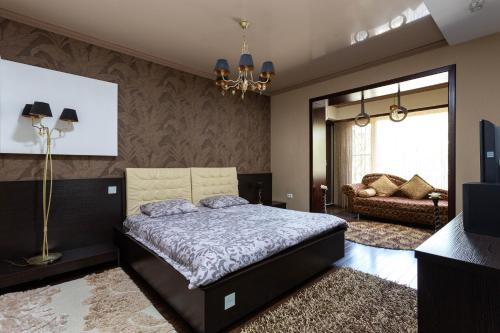 een slaapkamer met een bed en een bank bij Efendi Apartment in Tasjkent