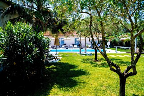 a yard with a swimming pool and trees at Hôtel Villa Sophia - ADULTS ONLY JULY AND AUGUST in Mougins