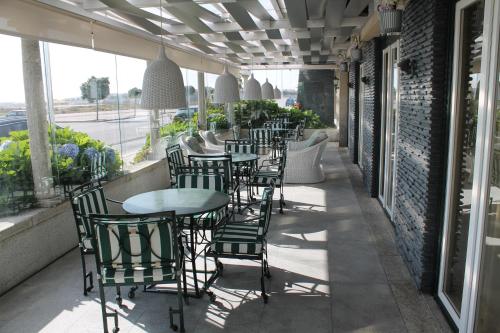 a row of tables and chairs on a patio at Hotel Suave Mar in Esposende