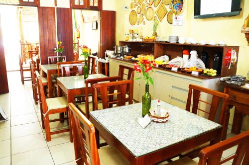 a restaurant with a table with flowers on it at Pousada Baobá e SPA in Olinda