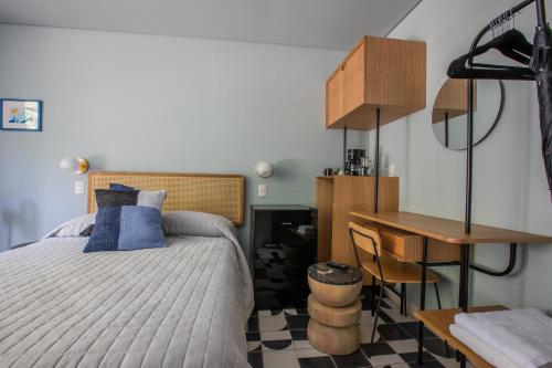a bedroom with a bed and a desk and a desk at Casa Ixaya by Barrio México in Guadalajara