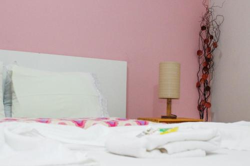 a bedroom with a bed with a pink wall at Pousada Doce Mel in Penedo