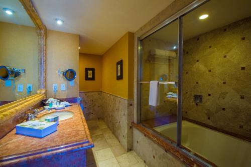 uma casa de banho com um chuveiro, um lavatório e uma banheira em Playa Grande Resort em Cabo San Lucas