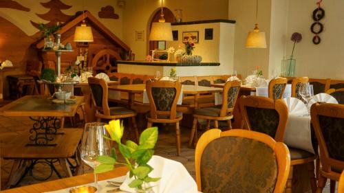 uma sala de jantar com mesas e cadeiras num restaurante em waldhotel AUSZEIT em Tanne