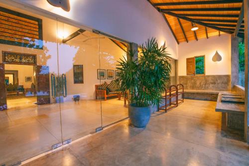 a large room with a potted plant in the middle at Gangananda in Ambalangoda