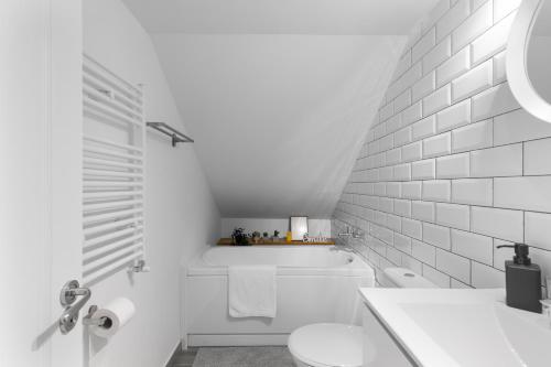 uma casa de banho branca com um WC e um lavatório em Historical Center 2 by CityLife Suites em Bucareste