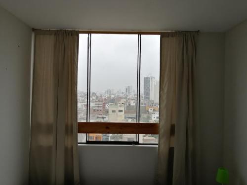 a window in a room with a view of a city at Blue Coast Lima private rooms Peru in Lima