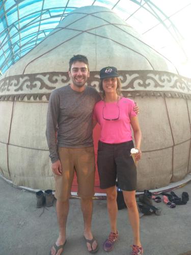 a man and a woman standing in front of a tent at Tündük Guest House, Karakol in Karakol