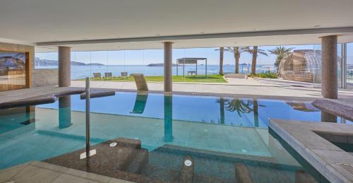 a swimming pool with a view of the ocean at Hotel Torre del Mar - Ibiza in Playa d'en Bossa