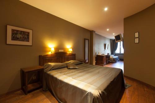 ein Schlafzimmer mit einem großen Bett und zwei Nachttischen in der Unterkunft Hotel Boterhuis in Brügge
