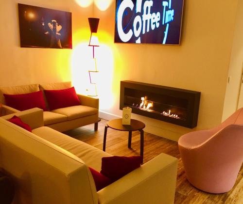 a living room with a couch and a fireplace at Hôtel Villa Sophia - ADULTS ONLY JULY AND AUGUST in Mougins