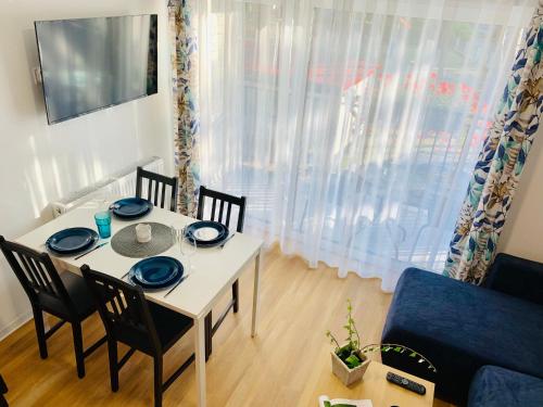 una mesa de comedor con platos azules en Wojtecki Apartamenty, en Pobierowo