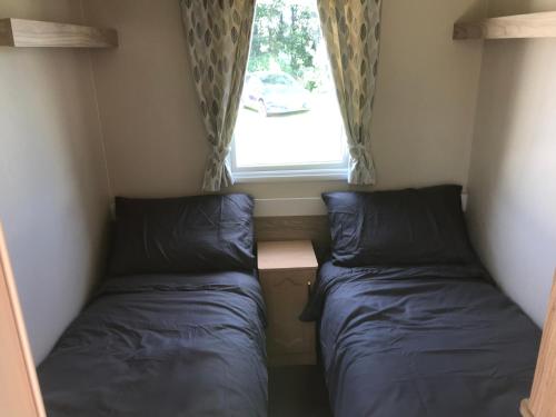 En eller flere senge i et værelse på 3 bedroom deluxe caravan