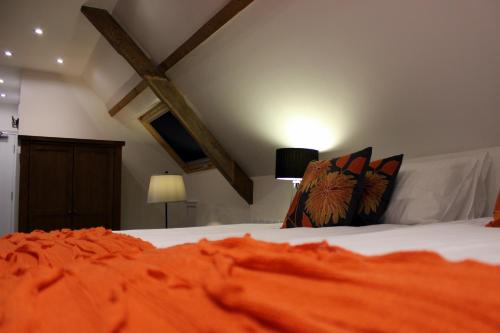 a bedroom with a bed with orange sheets and pillows at Kings Head Hotel in North Elmham
