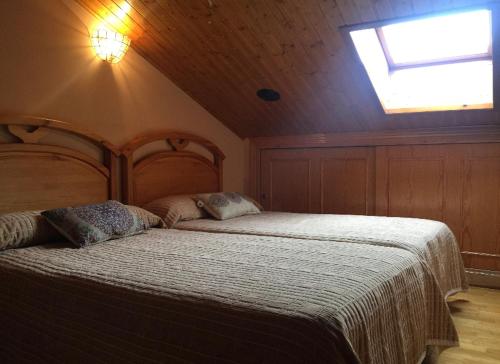 a bedroom with a large bed with a skylight at VIVIENDA DE USO TURÍSTICO CENTRO in Avila