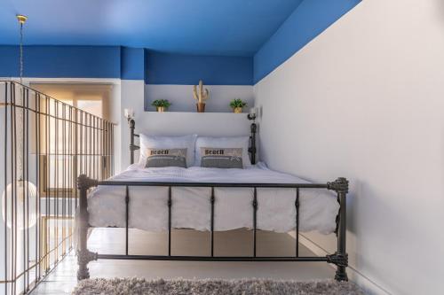 - une chambre avec un lit et un plafond bleu dans l'établissement Dreamy Loft Apt. 2Min Walk To The Beach+Netflix, à Tel Aviv