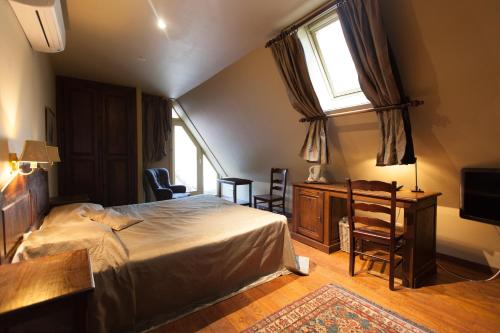 a bedroom with a bed and a desk and a window at Hotel Boterhuis in Bruges