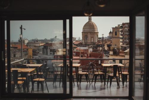 a room with tables and chairs and a view of a city at B&B Sweet Sleep in Naples
