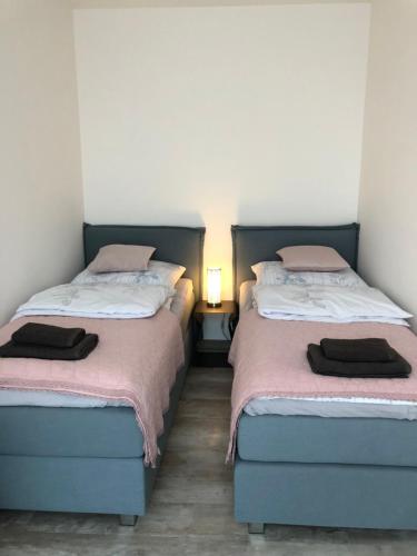duas camas sentadas uma ao lado da outra num quarto em Apartament LUX Green basen SPA Pięć Mórz Sianożęty em Poland